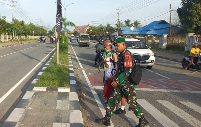 Peduli Keselamatan Anak Sekolah, Secara Rutin Babinsa Koramil Jajaran Kodim 1710/Mimika Bantu Seberangkan Jalan